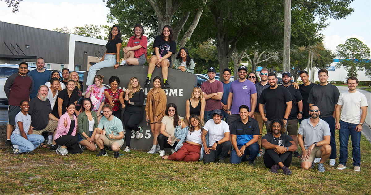 wholesome goods staff gather for group photo outside of office building